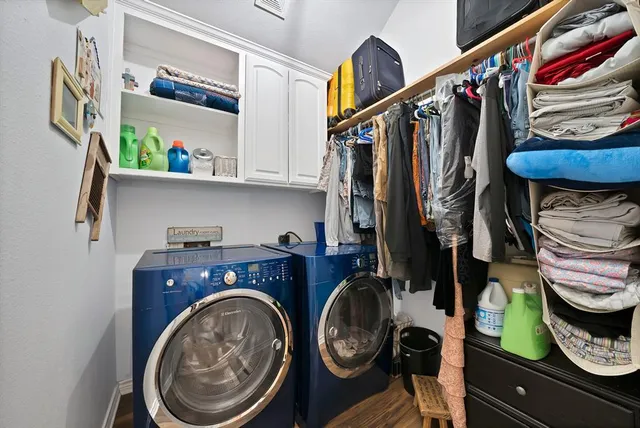 a utility room with lots of clutter and cabinets