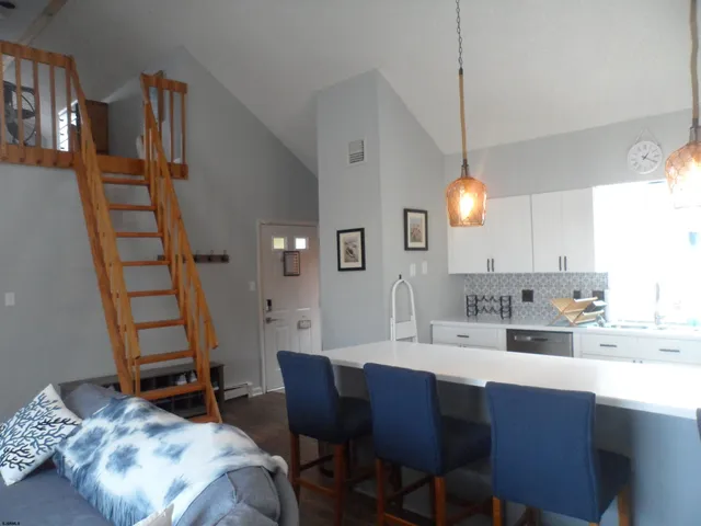 a kitchen with a dining table chairs and a wooden floor