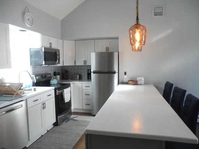 a kitchen with a refrigerator and a stove top oven