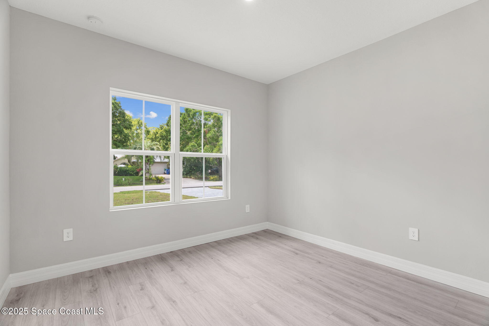 5915 Akers Street Cocoa, FL 32927 - Photo 20 of 33 an empty room with wooden floor and windows