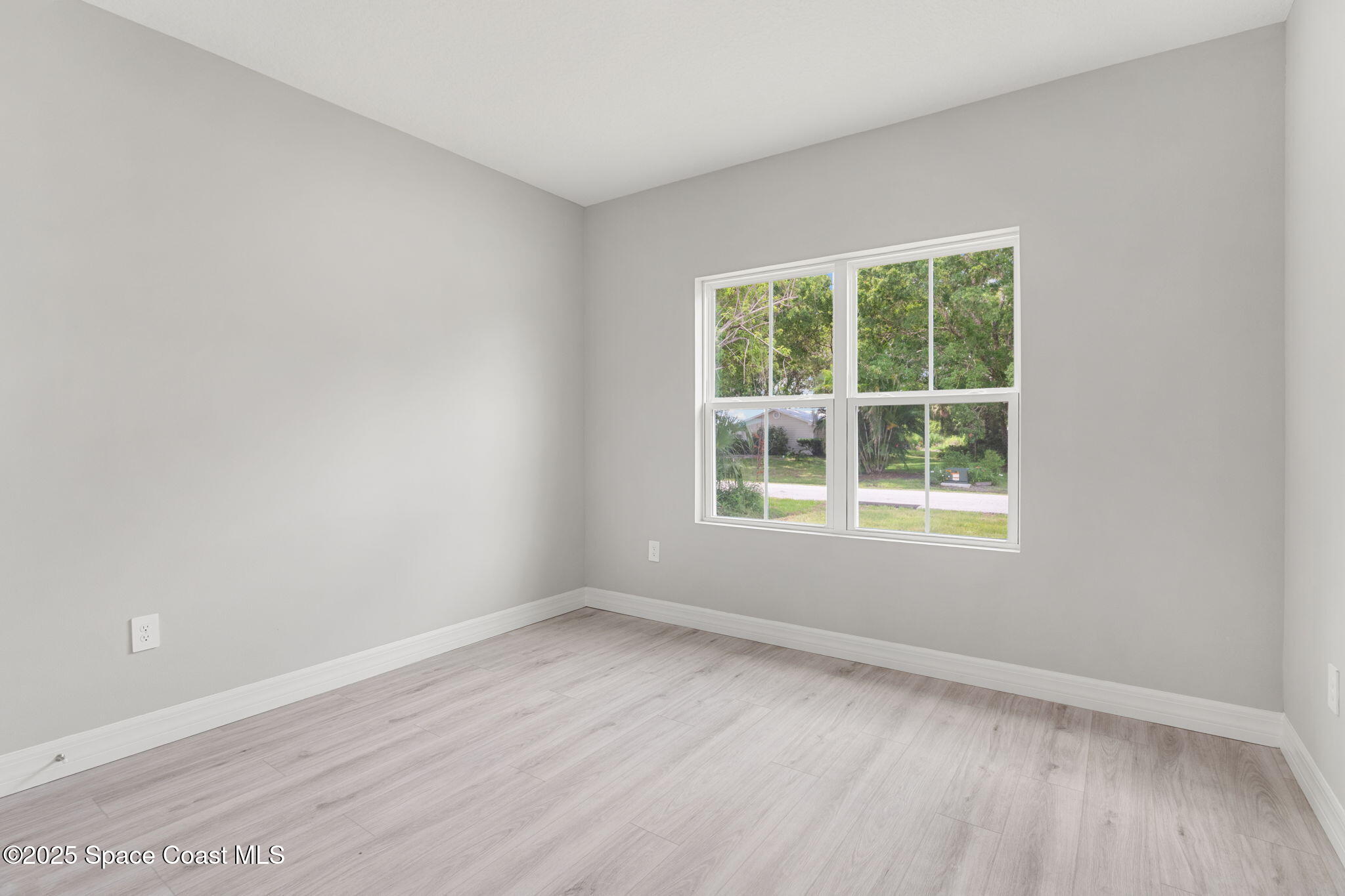 5915 Akers Street Cocoa, FL 32927 - Photo 24 of 33 an empty room with wooden floor and windows