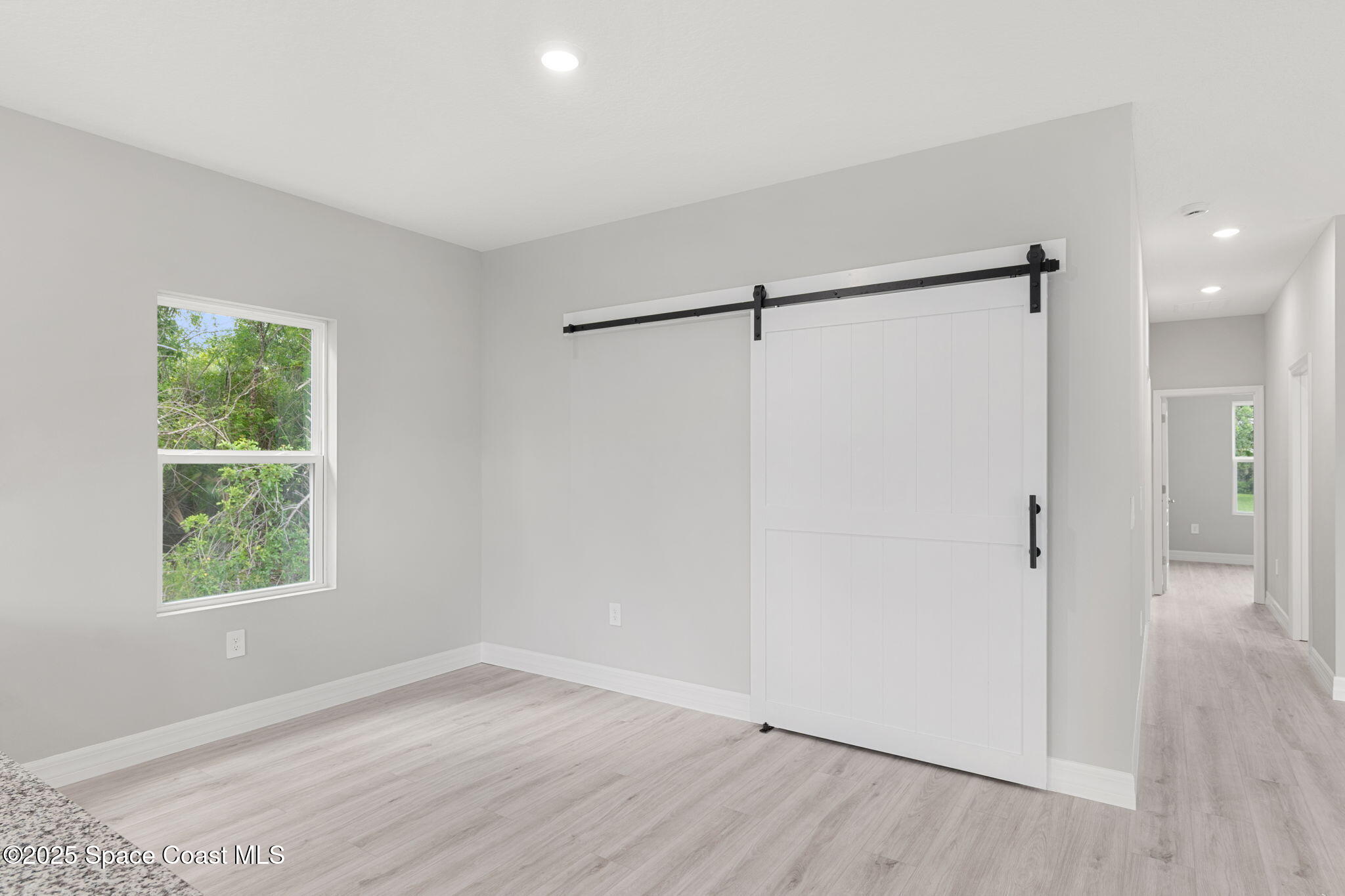 5915 Akers Street Cocoa, FL 32927 - Photo 27 of 33 an empty room with wooden floor a ceiling fan and windows