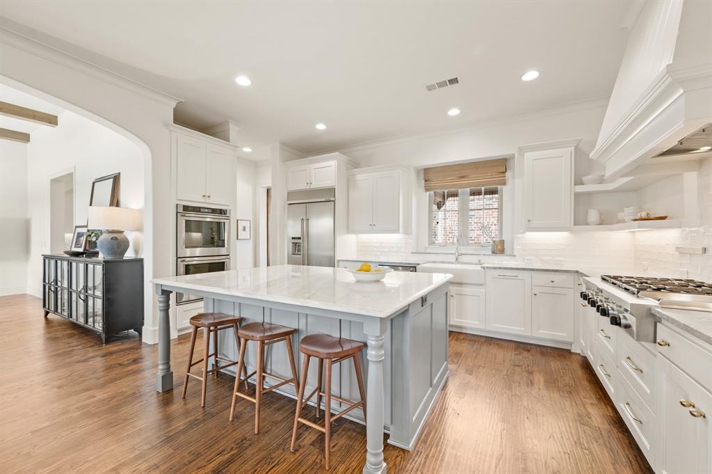 909 Winding Ridge Trail Southlake, TX 76092 - Photo 13 of 36 a kitchen with stainless steel appliances granite countertop a stove top oven a refrigerator a sink and white cabinets with wooden floor