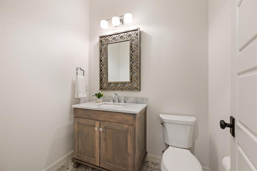 909 Winding Ridge Trail Southlake, TX 76092 - Photo 26 of 36 a bathroom with a toilet sink and mirror