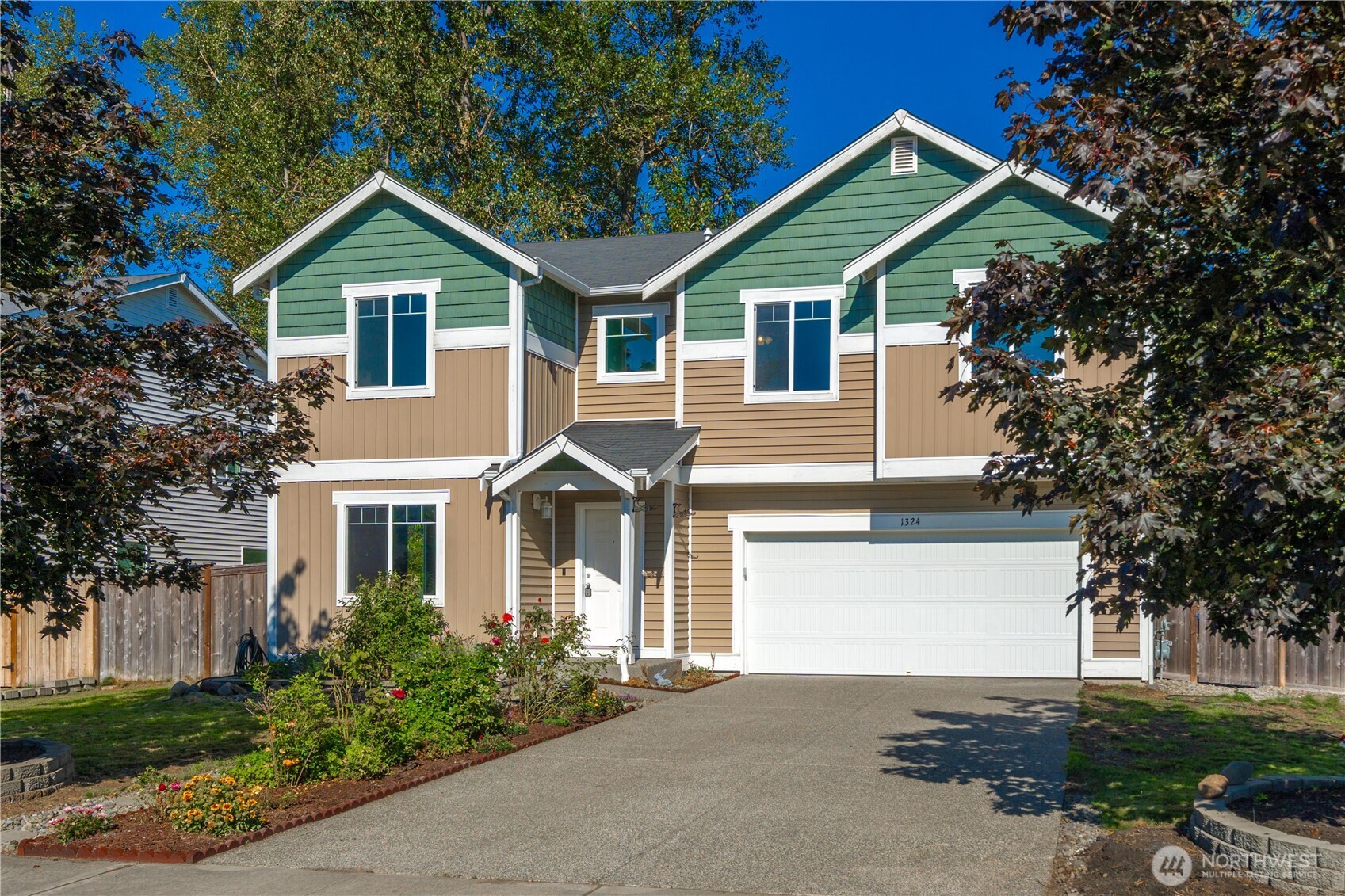 a front view of a house with a garden and plants