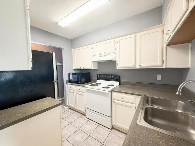 a kitchen with a stove a sink and a refrigerator