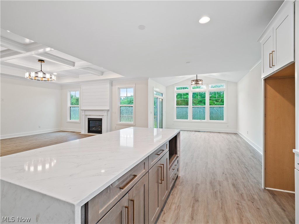 32 Brookside Lane North Ridgeville, OH 44039 - Photo 50 of 50 Kitchen with open floor plan, light wood-style flooring, a center island, light stone countertops, and beamed ceiling
