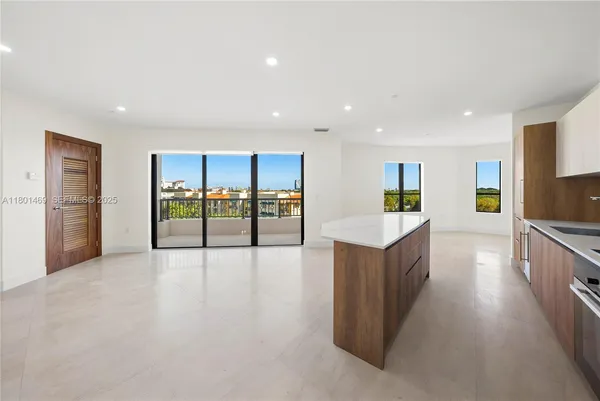 a view of a kitchen with furniture and a refrigerator