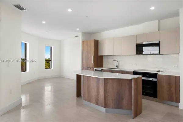 a kitchen with stainless steel appliances granite countertop a sink stove and microwave