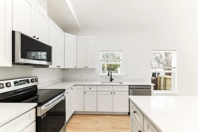 a kitchen with stainless steel appliances a stove microwave and cabinets