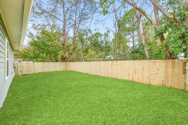 a view of yard with green space and wooden fence