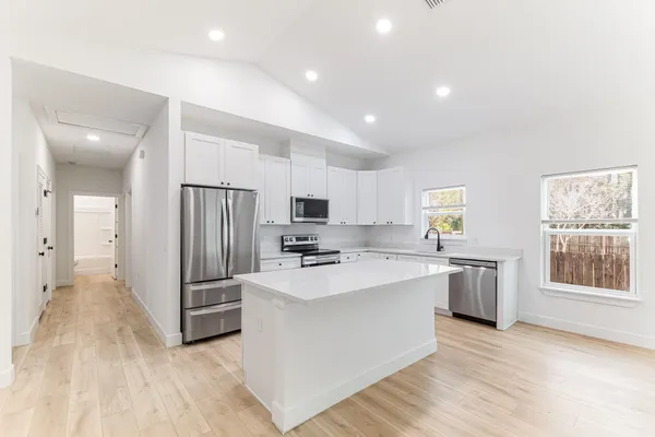a kitchen with stainless steel appliances a refrigerator and a stove top oven