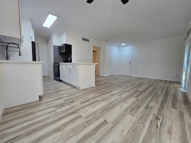 a view of a kitchen with microwave and cabinets