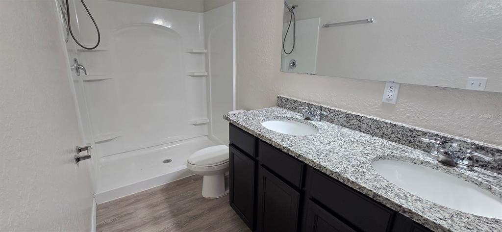 44 Walnut Road, Unit 4 Ocala, FL 34480 - Photo 7 of 7 a bathroom with a granite countertop sink a toilet and shower