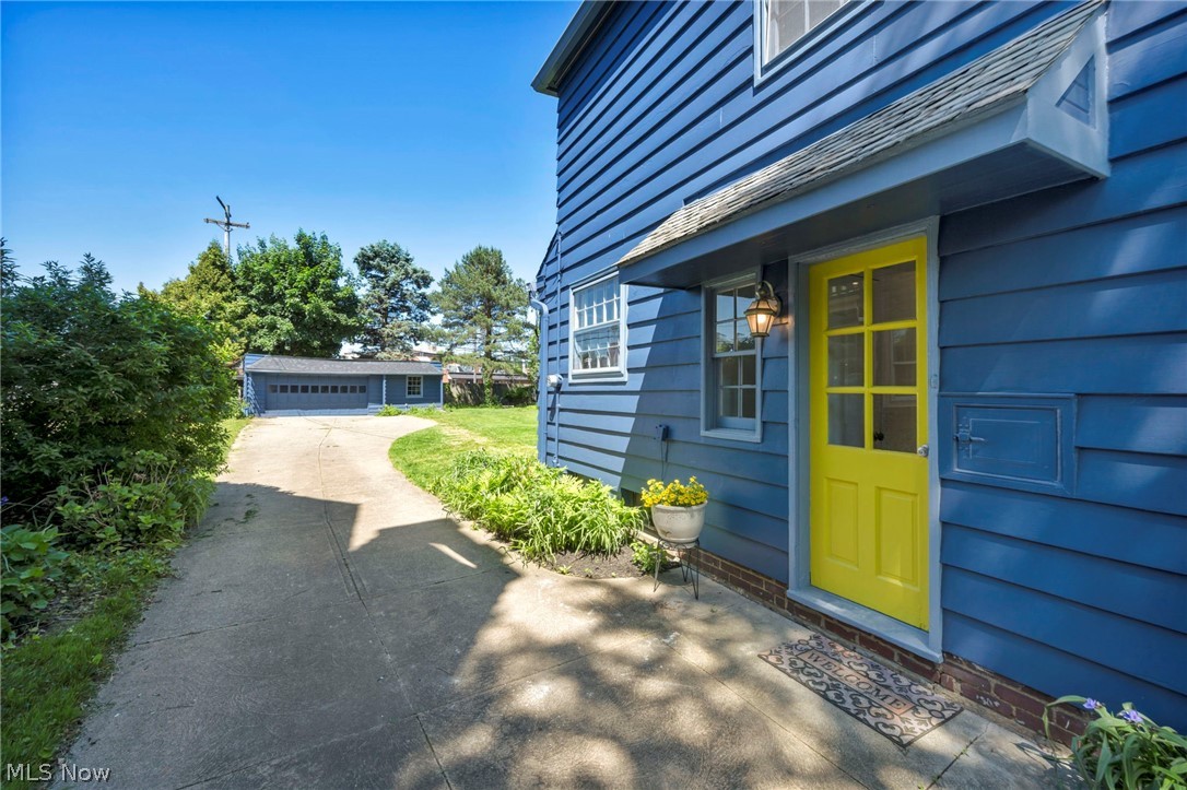 3543 Lytle Road Shaker Heights, OH 44122 - Photo 45 of 49 Blue horizontal siding with a bright yellow multi-pane door, featuring an overhead porch canopy and exterior lighting