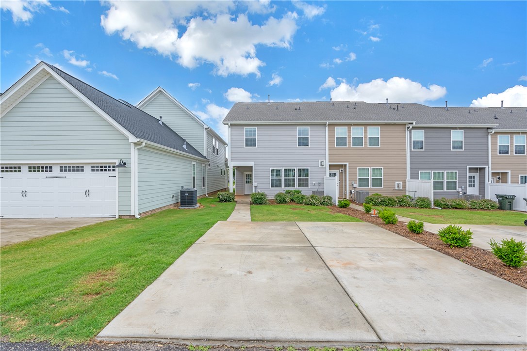 8 Leander Drive Greer, SC 29651 - Photo 31 of 31 A row of modern townhomes featuring attached garages and manicured green spaces.