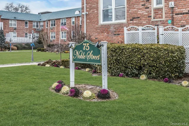 a sign that is sitting in front of a brick building