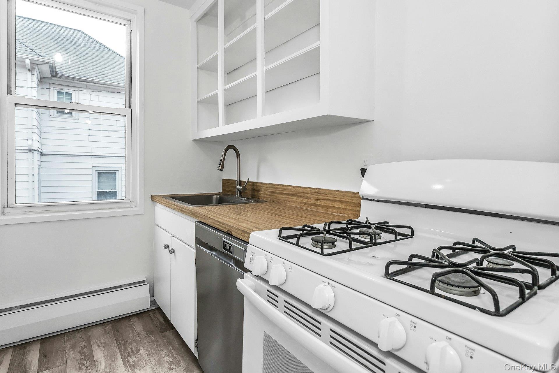 75 Noble Street, Unit 121 Lynbrook, NY 11563 - Photo 9 of 24 a kitchen with a stove and a window