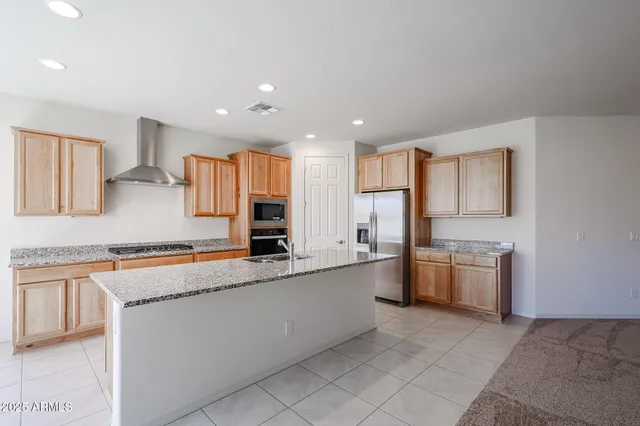 a large kitchen with stainless steel appliances granite countertop a sink and a stove top oven