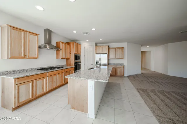 a large kitchen with stainless steel appliances kitchen island granite countertop a sink and cabinets