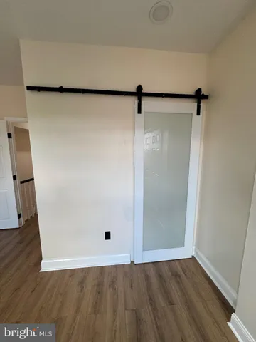 an empty room with wooden floor and mirror