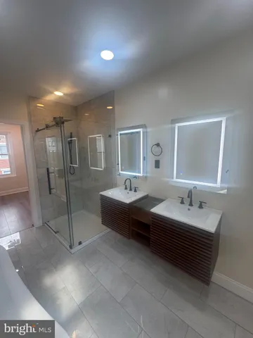 a spacious bathroom with a double vanity sink and a mirror