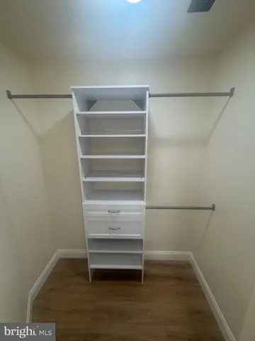 a view of walk in closet with empty racks