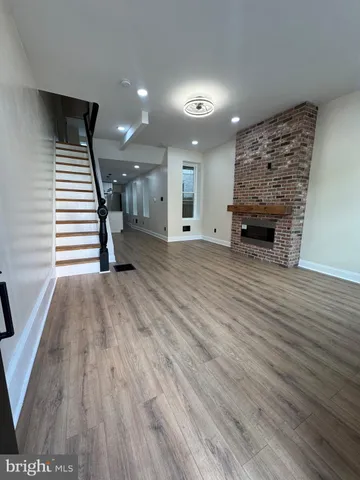 a view of a livingroom with wooden floor and staircase