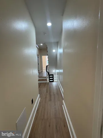 a view of a hallway with wooden floor