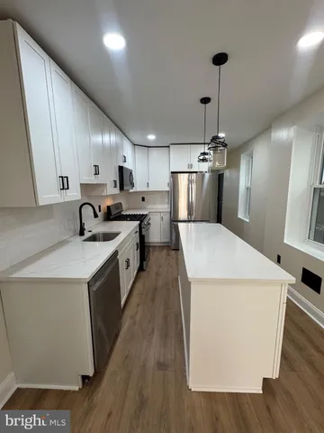 a kitchen with a sink a stove a refrigerator and cabinets