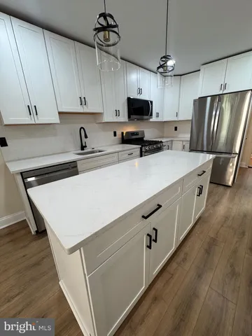 a kitchen with stainless steel appliances a stove refrigerator sink and microwave
