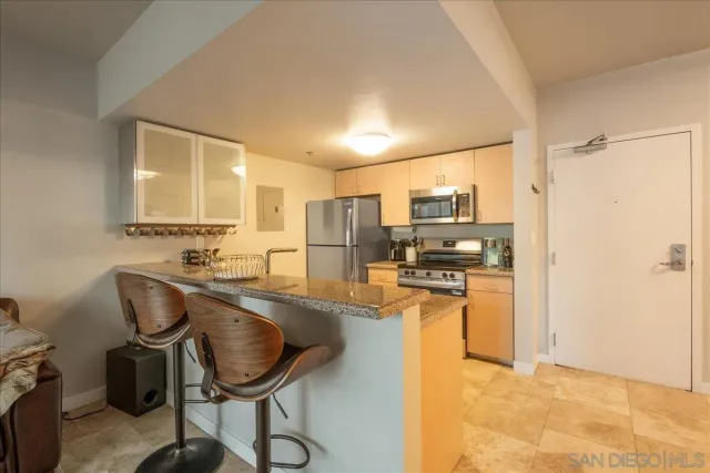 a kitchen with stainless steel appliances granite countertop a refrigerator and a stove top oven