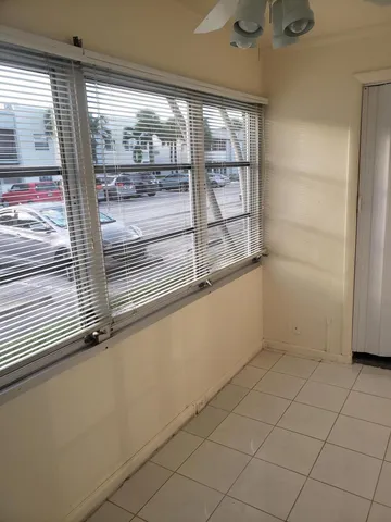 a room with a chandelier fan and window
