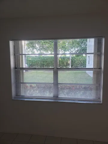 an empty room with windows and ceiling fan