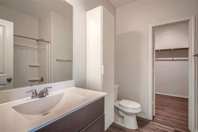 a bathroom with a bathtub shower sink vanity mirror and toilet