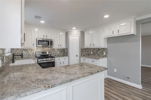 a kitchen with stainless steel appliances granite countertop a sink stove and refrigerator