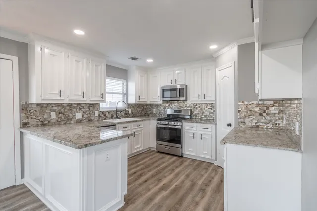 a kitchen with a refrigerator stove top oven and sink