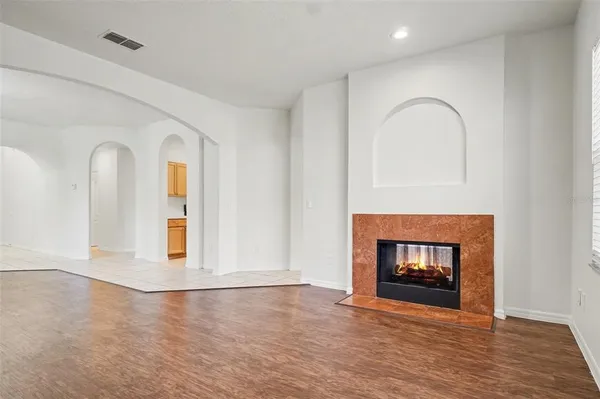 an empty room with windows fire place and fireplace