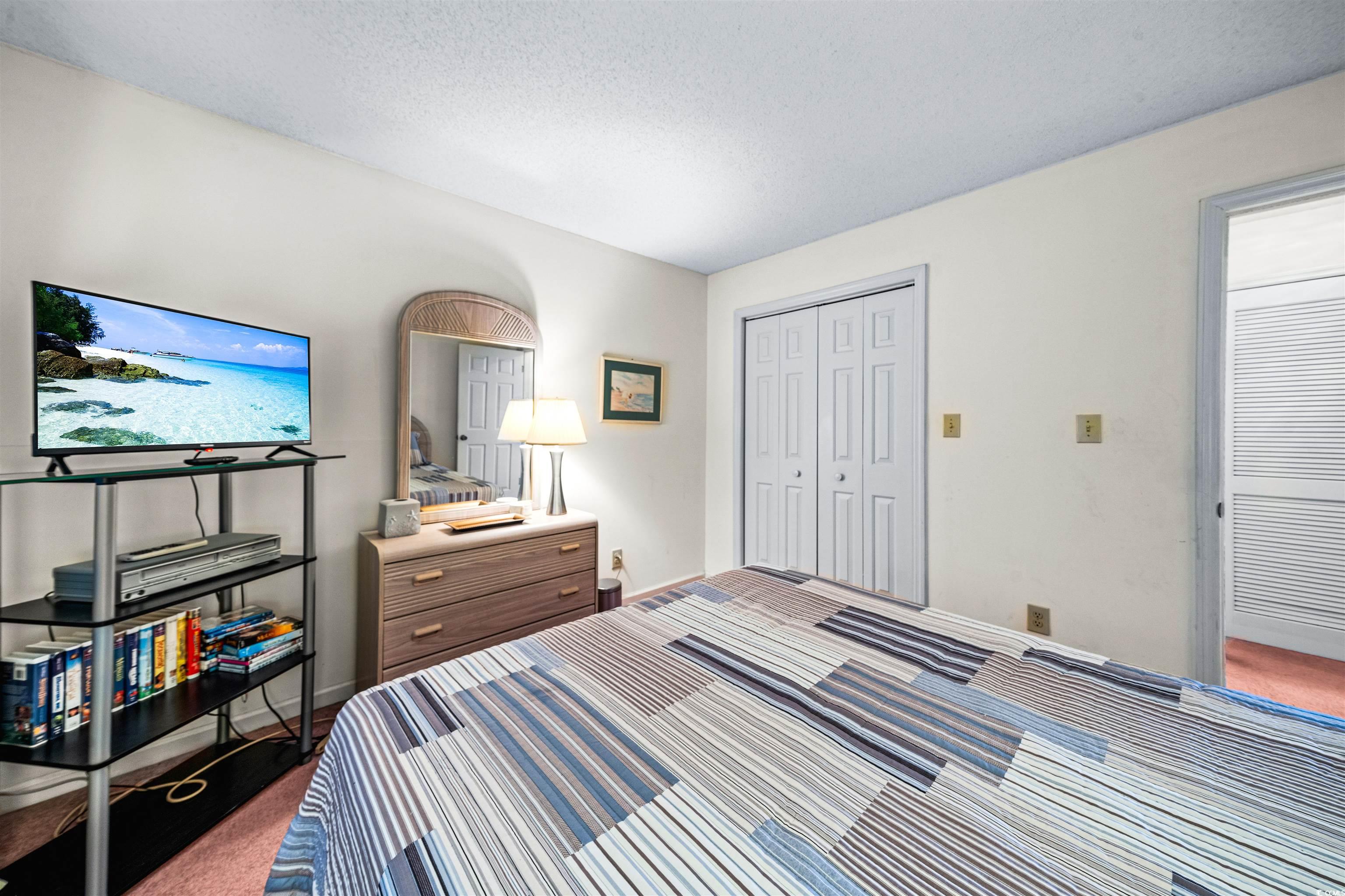 207 Landing Road, Unit F North Myrtle Beach, SC 29582 - Photo 19 of 27 Carpeted bedroom with a textured ceiling and a clo
