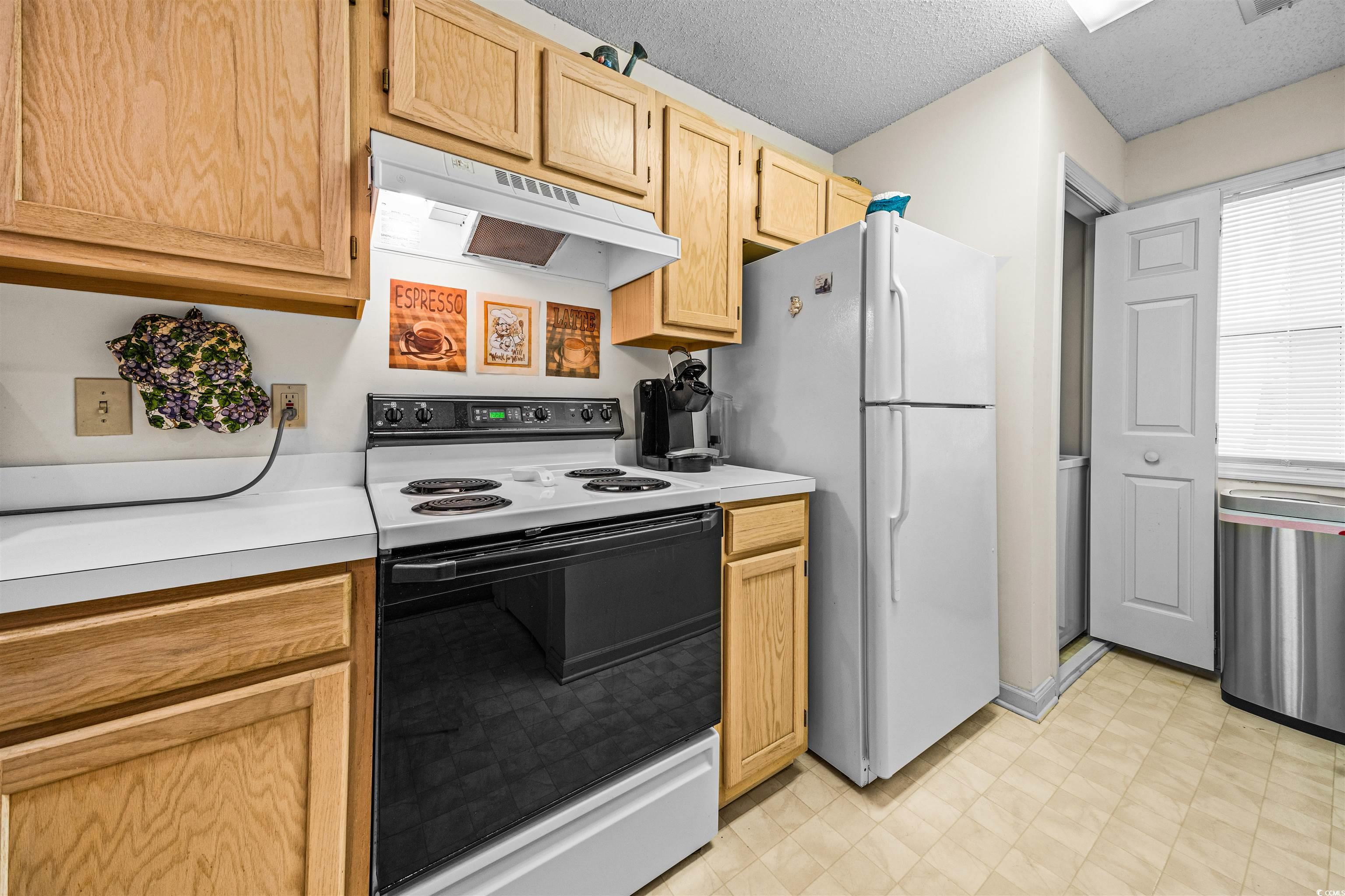 207 Landing Road, Unit F North Myrtle Beach, SC 29582 - Photo 5 of 27 Kitchen with light brown cabinets, white appliance