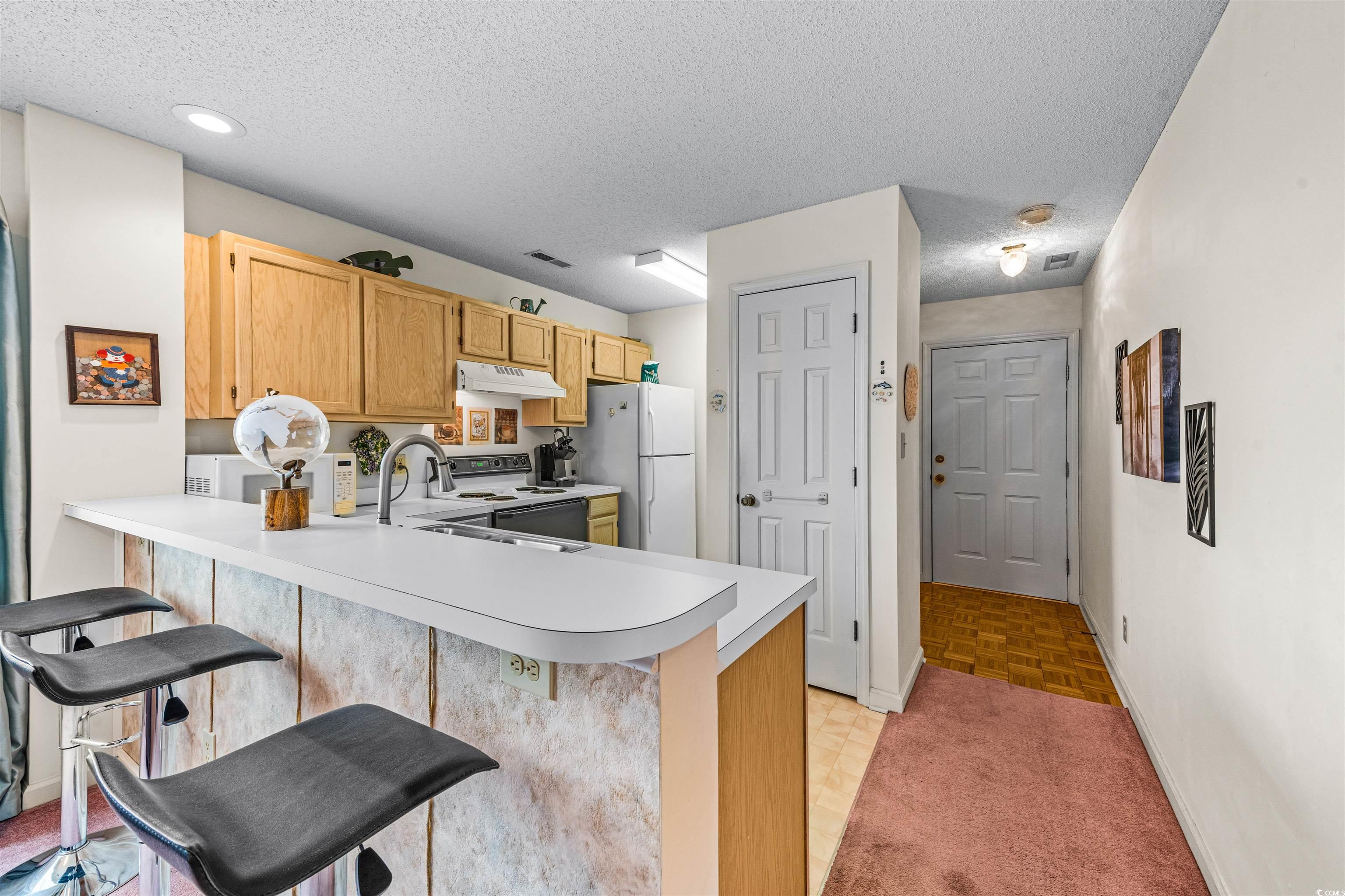 207 Landing Road, Unit F North Myrtle Beach, SC 29582 - Photo 6 of 27 Kitchen with a breakfast bar, white appliances, an