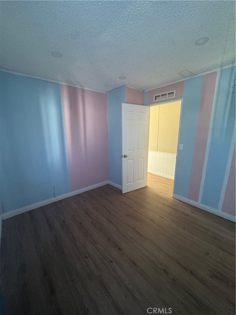 2751 Reche Canyon Road, Unit 4 Moreno Valley, CA 92555 - Photo 11 of 12 a view of an empty room with wooden floor and a window