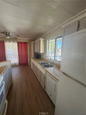a kitchen with granite countertop a sink stove and cabinets