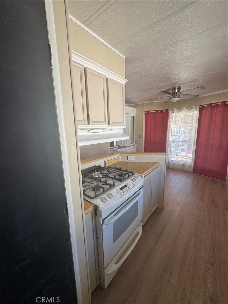 2751 Reche Canyon Road, Unit 4 Moreno Valley, CA 92555 - Photo 7 of 12 a kitchen with a stove wooden floor and a window