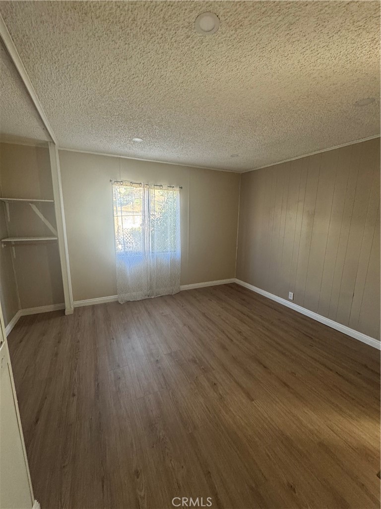 2751 Reche Canyon Road, Unit 4 Moreno Valley, CA 92555 - Photo 9 of 12 an empty room with wooden floor and windows