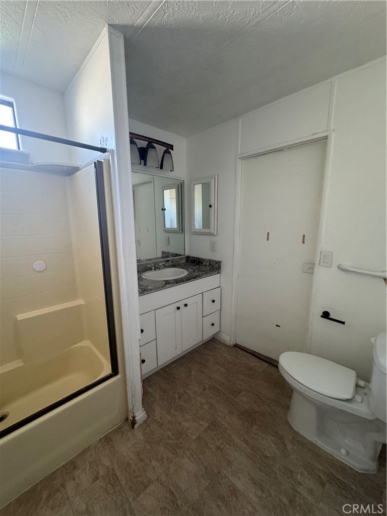 2751 Reche Canyon Road, Unit 4 Moreno Valley, CA 92555 - Photo 10 of 12 a bathroom with a granite countertop sink toilet and shower