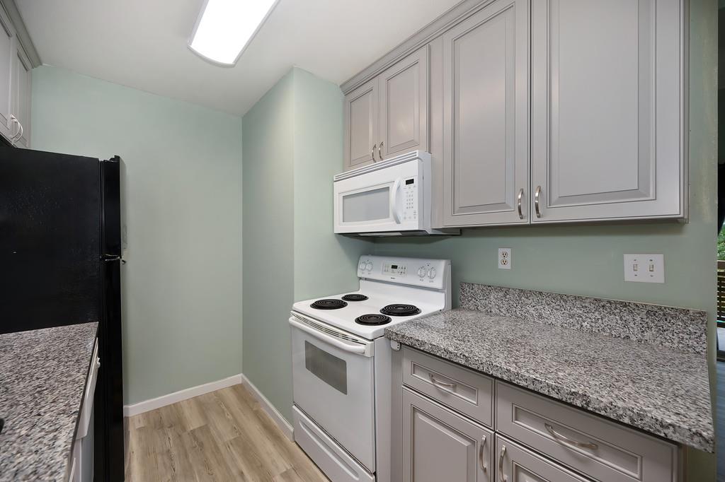 9160 Madison Avenue, Unit 68 Fair Oaks, CA 95628 - Photo 16 of 35 a kitchen with granite countertop cabinets and white appliances