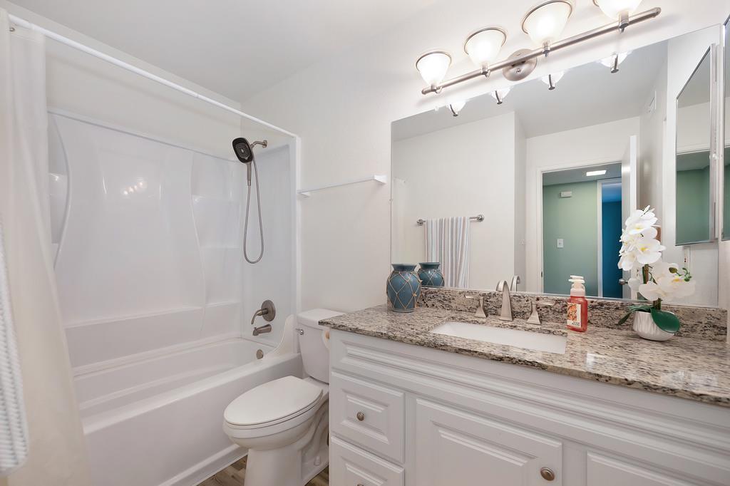 9160 Madison Avenue, Unit 68 Fair Oaks, CA 95628 - Photo 26 of 35 a bathroom with a granite countertop toilet a sink and a bathtub