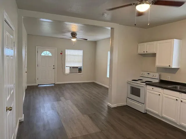 a kitchen with granite countertop a stove and a wooden floors
