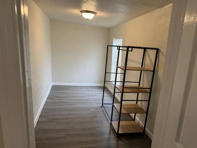 a view of a hallway with wooden floor and entryway
